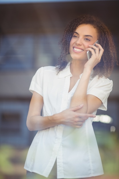 Lächelnde Frau, die am Telefon spricht