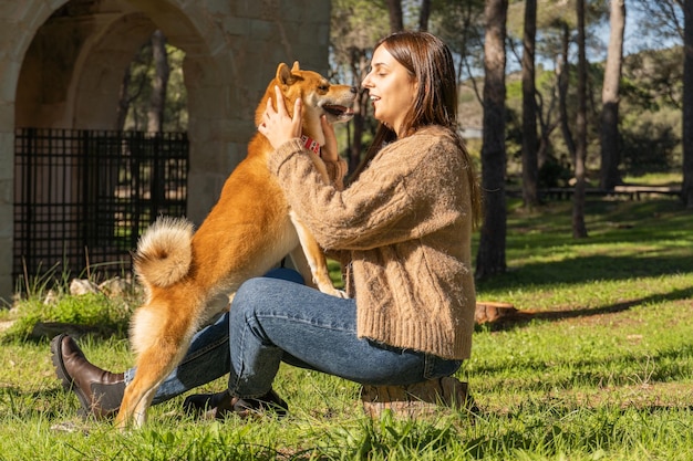 Lächelnde Frau, die einen Shiba-Inu-Hund umarmt