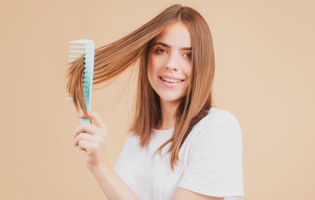 Lächelnde Frau, die Haare mit Kamm bürstet schönes Mädchen mit langer Haarbürste