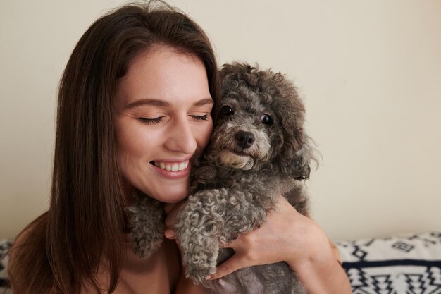 Lächelnde Frau, die Hund umarmt