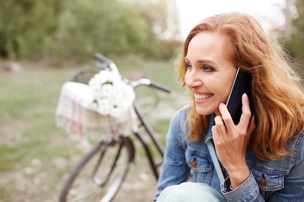 Lächelnde Frau, die mit dem Handy spricht