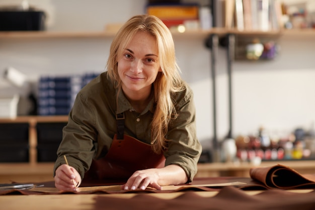 Lächelnde Frau, die mit Leder arbeitet