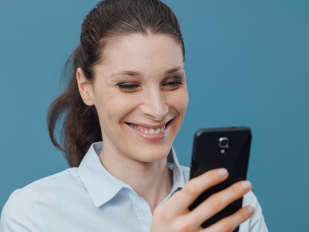 Lächelnde Frau, die sich mit ihrem Smartphone verbindet