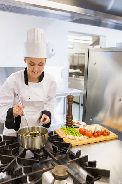 Lächelnde Frau, die Suppe macht