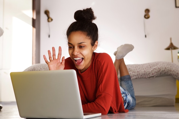 Lächelnde Frau, die Videoanruf auf Laptop macht