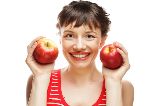 Lächelnde Frau, die zwei rote Äpfel hält