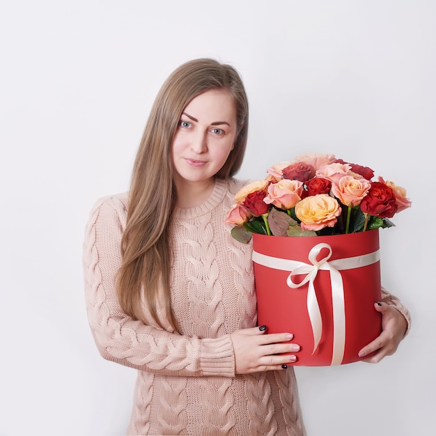 Lächelnde Frau halten rote Geschenkbox. Konzept des Valentinsgrußes