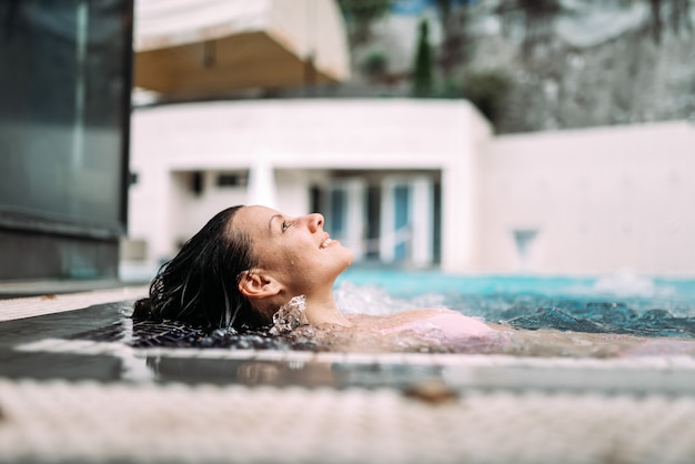 Lächelnde Frau im Pool am Kurort.