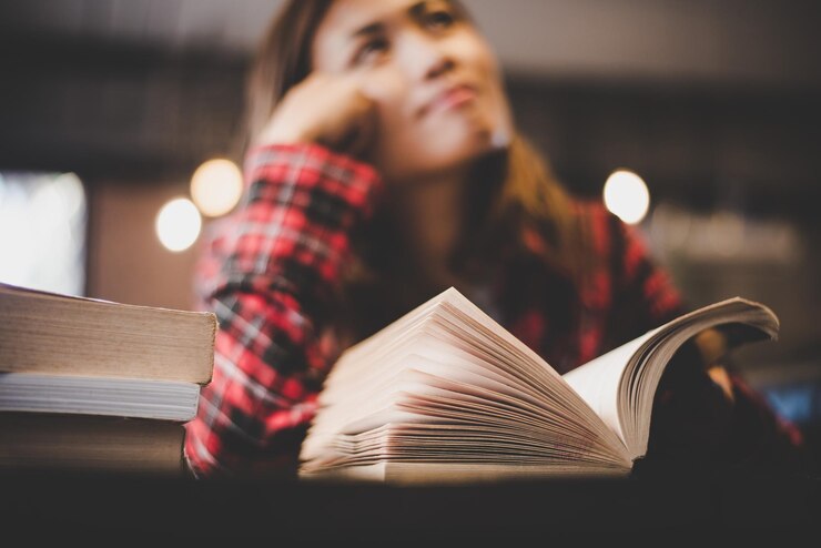 Foto lächelnde frau mit buch auf dem tisch im restaurant