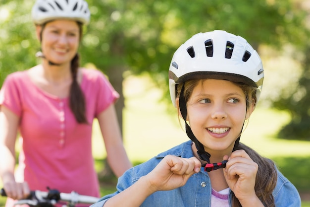 Lächelnde Frau mit ihrer Tochter, die Fahrrad fährt