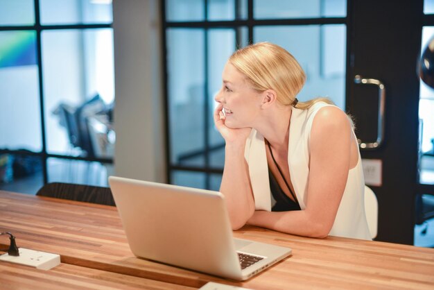 Foto lächelnde frau mit laptop im büro