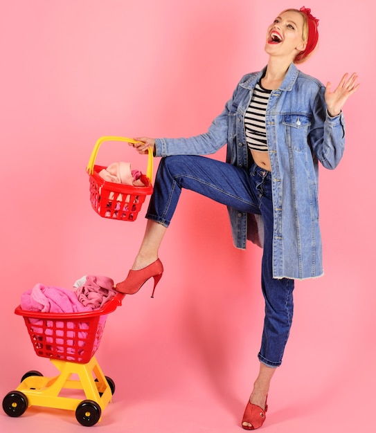 Lächelnde Frau mit vollem Warenkorb im Supermarkt. Pinup-Girl mit Einkaufskorb.