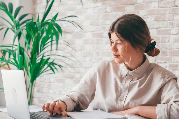 Lächelnde Frau schreibt Notizen, sieht sich Webinar an, studiert, arbeitet am Laptop, junge Studentin lernt Computerkurs, hört Vorlesung, Schulung, Dolmetscher, Online-Lehrer, übersetzt classxA