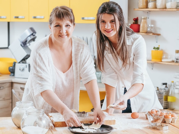 Lächelnde Frauen, die in der Familienküche aufwerfen