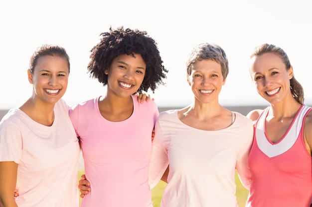 Foto lächelnde frauen, die rosa für brustkrebs tragen