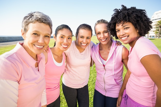 Foto lächelnde frauen, die rosa für brustkrebs tragen