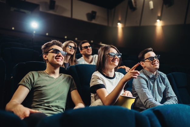 Lächelnde Freunde, die 3D-Film im Kino ansehen. Showtime, Technologien der Unterhaltungsindustrie