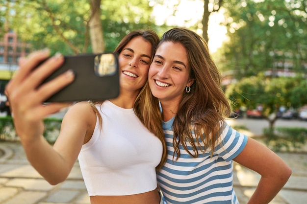 Foto lächelnde freunde, die im park ein selfie machen