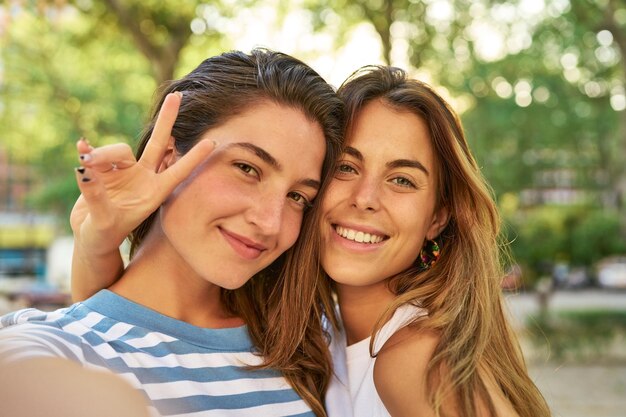 Lächelnde Freunde, die im Park ein Selfie machen