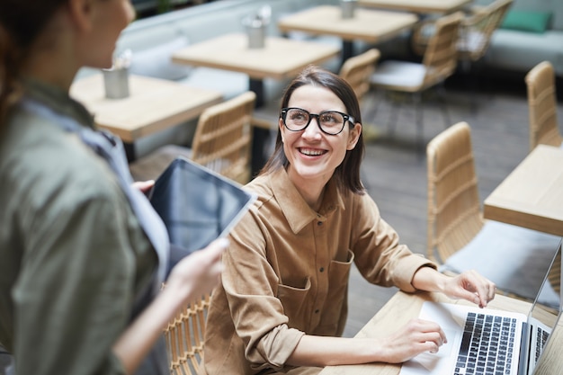 Lächelnde Geschäftsfrau, die Kaffee im Cafe bestellt