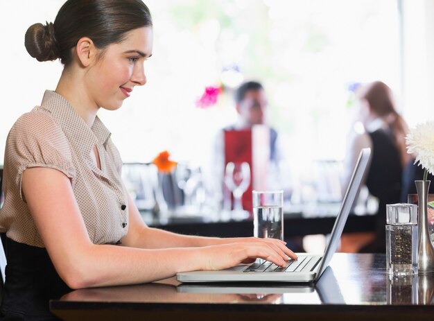 Lächelnde Geschäftsfrau, die Laptopbildschirm betrachtet