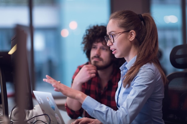 Lächelnde Geschäftsfrau mit Erfahrung in der Arbeit an Business-Projekten, die einen Mitarbeiter coachen