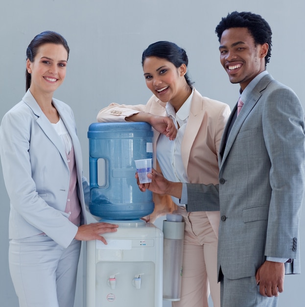 Lächelnde Geschäftsleute mit einem Wasserkühler im Büro