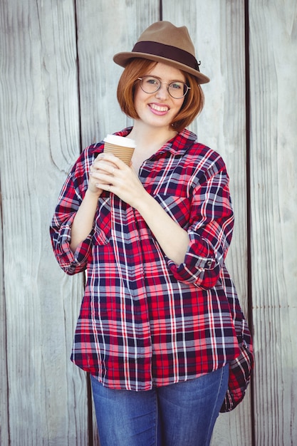 lächelnde Hippie-Frau, die eine Kaffeetasse hält