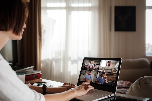 Lächelnde junge asiatische Frau Videoanruf auf Laptop