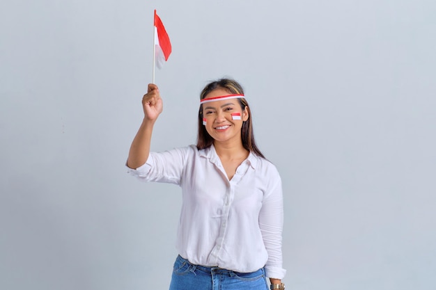 Lächelnde junge asiatische Frauen mit der indonesischen Flagge isoliert auf weißem Hintergrund Indonesisches Unabhängigkeitstag-Konzept