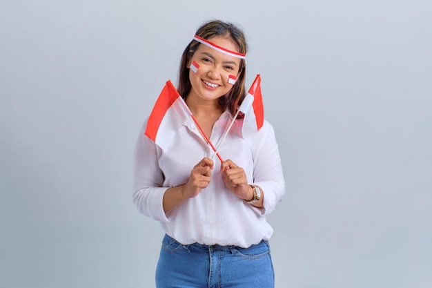 Lächelnde junge asiatische Frauen mit der indonesischen Flagge isoliert auf weißem Hintergrund Indonesisches Unabhängigkeitstag-Konzept