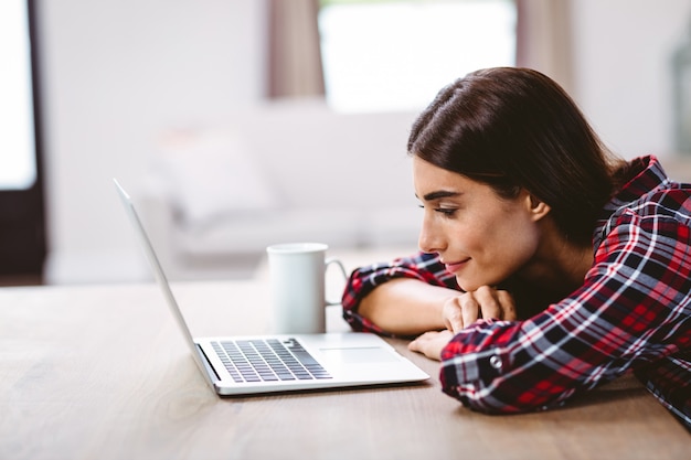 Lächelnde junge Frau, die Laptop betrachtet