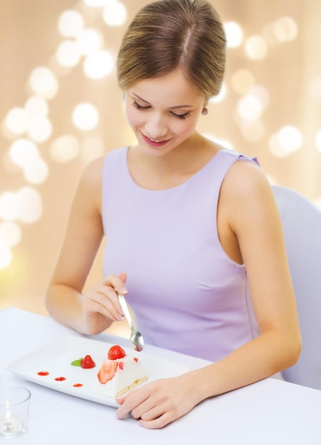 lächelnde junge Frau isst Dessert im Restaurant