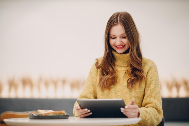 Lächelnde junge Frau mit einem digitalen Tablet