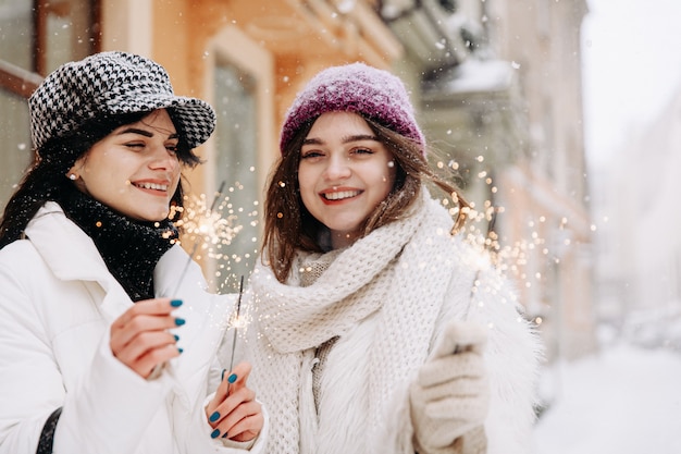 Lächelnde junge Frauen, die warme Winterkleidung plaudern