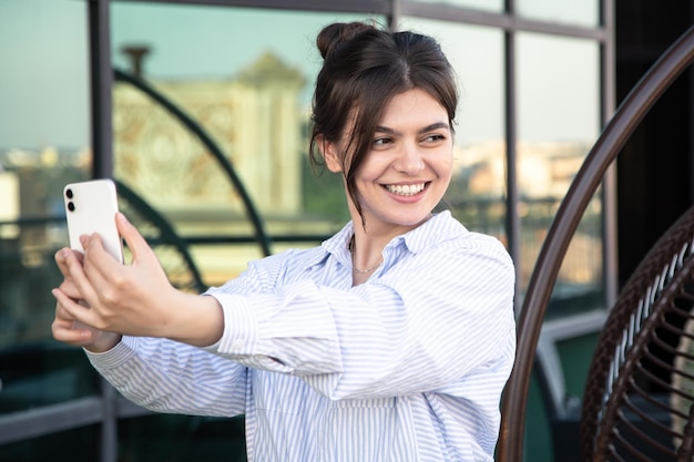 Lächelnde junge Geschäftsfrau macht ein Selfie auf einem Smartphone