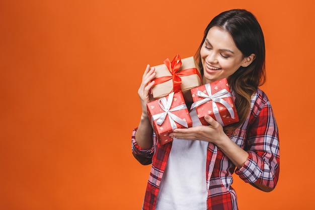 Lächelnde junge schöne Frau hält rote Geschenkbox