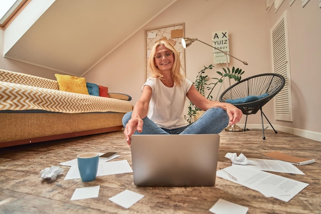 Foto lächelnde kaukasische frau mittleren alters, die am boden arbeitet