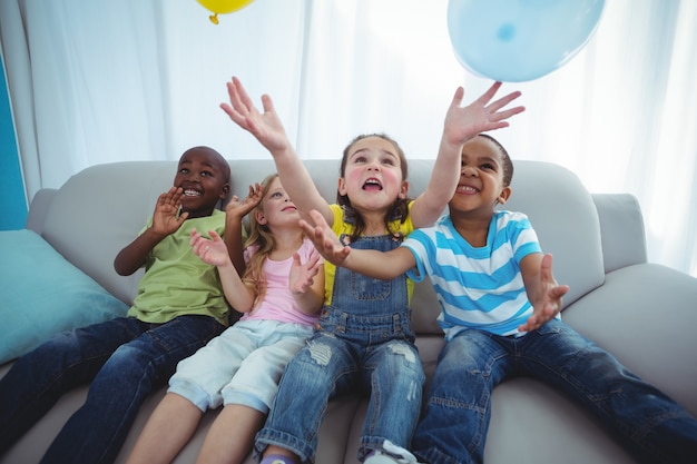 Lächelnde Kinder, die mit Ballonen spielen