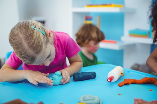 Lächelnde Kinder, die Modellierton verwenden