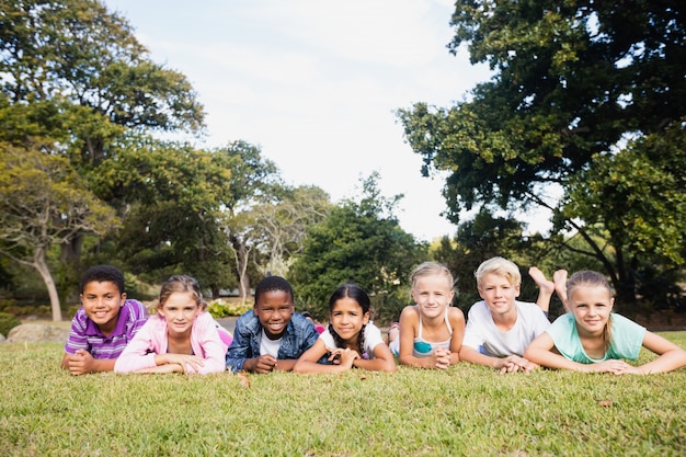 Lächelnde Kinder, die zusammen während eines sonnigen Tages aufwerfen