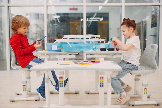 Lächelnde Kinder, Jungen und Mädchen, Kinderkonstrukteur, der technisches Spielzeug überprüft. Kinderrobotik-Konstrukteur montieren Roboter