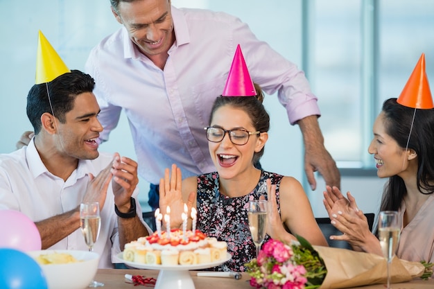 Lächelnde Kollegen feiern Geburtstag der Frau