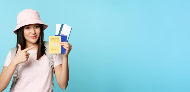Foto lächelnde koreanische touristin zeigt ihren pass-impfpass von der coronavirus-krankheit, die v
