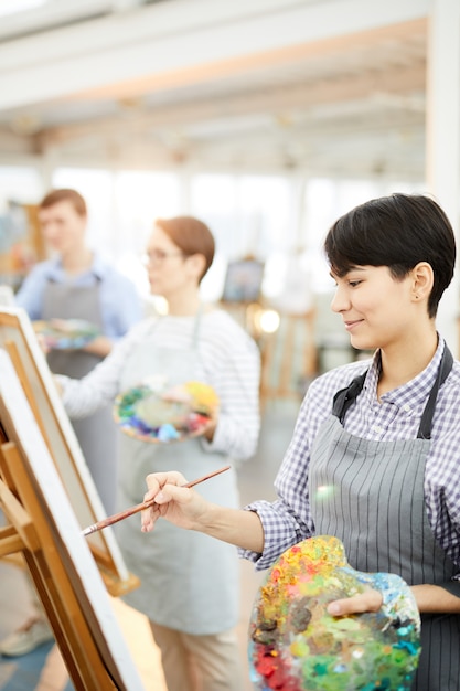 Lächelnde Künstler, die im Studio arbeiten