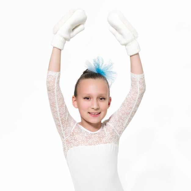 Lächelnde Mädchen-Balletttänzerin im weißen Ballett-Tutu-Rock, die Arme in Fäustlingen erhoben Studioaufnahme Ballerina