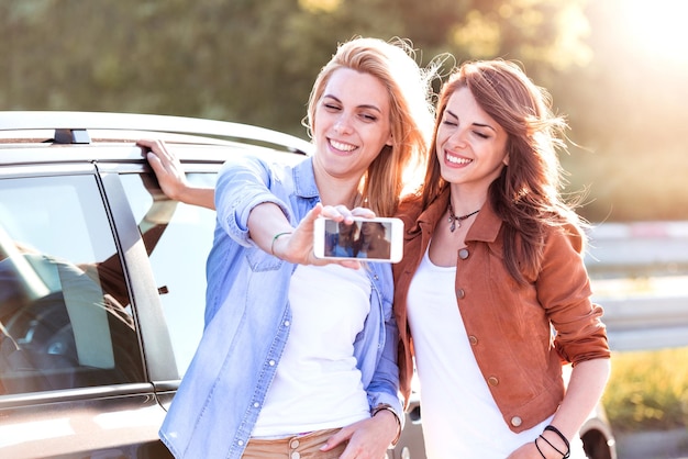 Lächelnde Mädchen, die sich mit dem Smartphone in der Stadt selbst machen