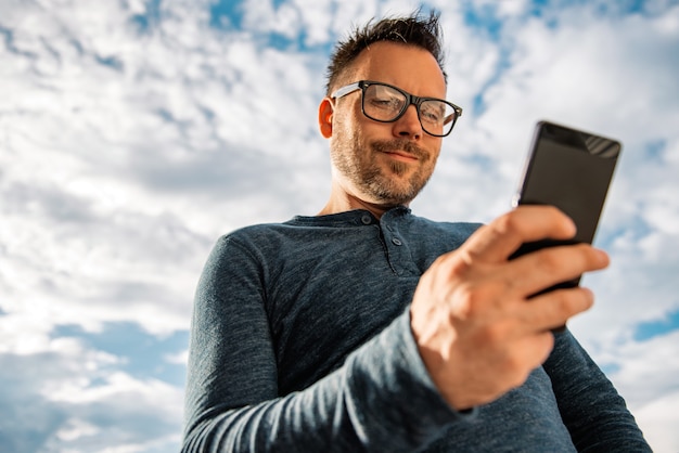 Lächelnde Männer, die Textnachricht schreiben