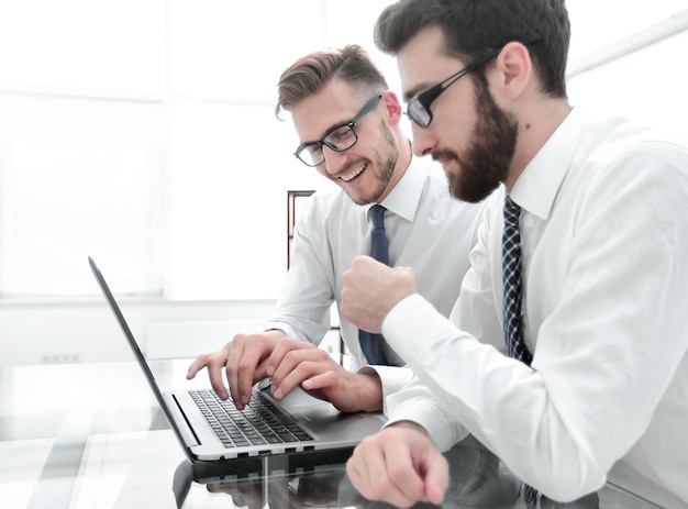 Lächelnde Mitarbeiter am Schreibtisch im Büro