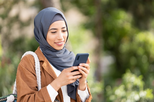 Lächelnde muslimische Frau mit einem Handy Nahaufnahme